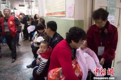 资料图:家长带着儿童在排队等候接种疫苗。韦亮 摄